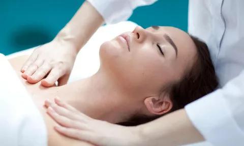 Therapist providing a gentle neck and shoulder massage